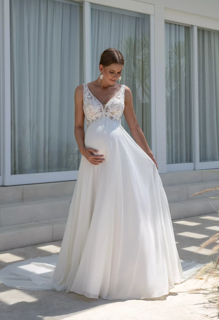 Schwangere Braut trägt weisses, fließendes Brautkleid mit Babybauch, Brautkleid von Dolce Vita Huegelheim Curvy Brutmoden